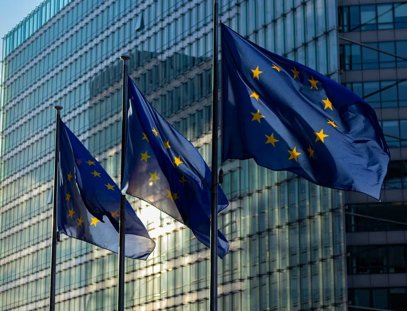 European Union flags waving outside a government building